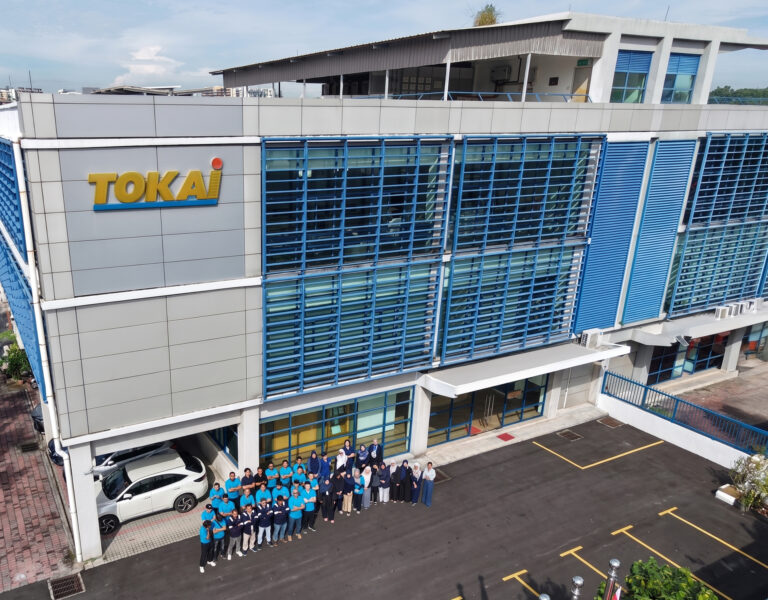 Tokai Headquarters with staff posing in front of Tokai building entrance
